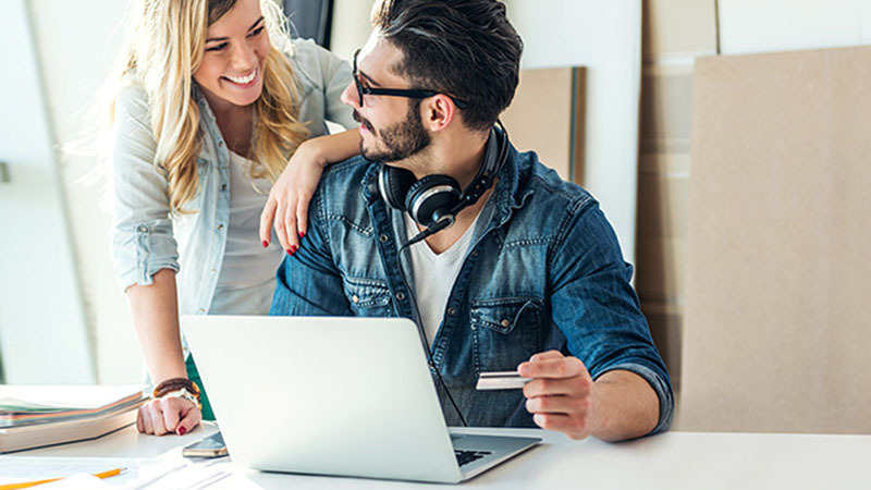 Homem e mulher se olhando em frente ao computador