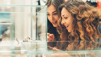 mujeres frente a una vidriera mirando unas joyas
